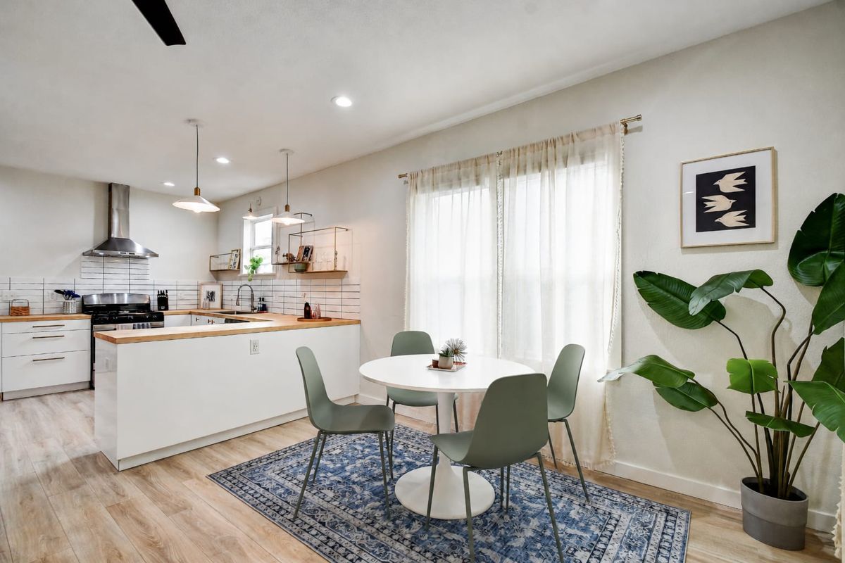 Dining nook with round table and kitchen beyond at The Waverly – West